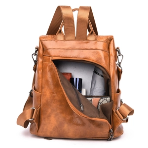Detailed interior of brown anti-theft PU leather backpack showing large storage capacity