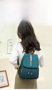 Detail of dark green waterproof oxford backpack with striped straps and drawstring closure