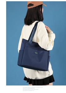 Détail du grand sac cabas en nylon bleu foncé montrant la poche latérale et l'intérieur