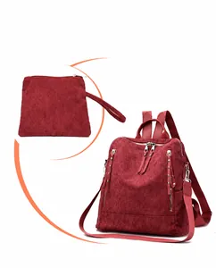 Detailed view of burgundy corduroy backpack and matching pouch with premium texture