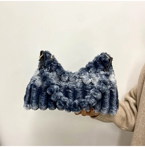 Detail of blue gradient plush handbag with wavy texture and durable black handles