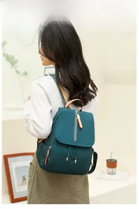 Dark green water-resistant oxford backpack with drawstring closure shown on model