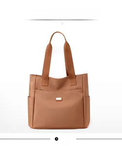 Vue de face du grand sac cabas en nylon marron avec logo en métal et fermeture éclair