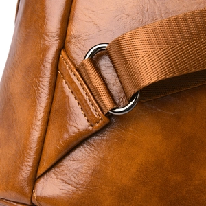 Detail of brown crocodile pattern PU leather bag showing D-ring and nylon strap