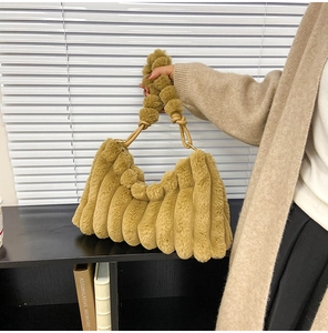 Detail of caramel faux fur tote bag with plush textured stripes and fuzzy ball handle