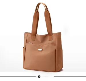 Vue latérale du sac fourre-tout en nylon caramel avec poche zippée et poches latérales