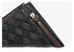 Détail d'un sac en cuir noir matelassé avec fermeture éclair et boucles dorées