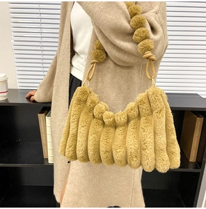 Detail of khaki plush shoulder bag with vertical stripes and fluffy ball strap with metal rings