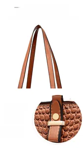 Detailed macro view of the brown crocodile embossed leather texture and gold hardware