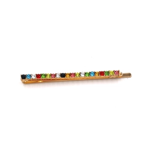 Detail of gold metal hair clip with a rainbow row of multi-colored round rhinestones