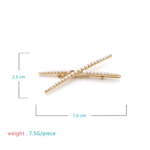 Detail of gold X-shaped hair clip with gradient white pearls and 7cm size dimensions