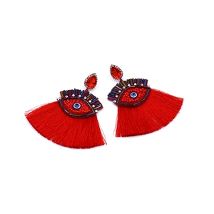 Detail view of red bohemian evil eye tassel earrings with vibrant beaded accents