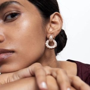 Elegant rose gold hoop earrings with pavé crystals shown on a model for a luxury look