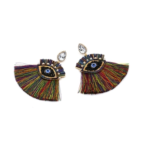 Detailed view of colorful tassel earrings featuring evil eye beadwork and crystal studs
