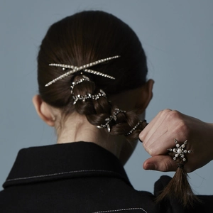 Elegant pearl and rhinestone hair clip set on a model's braided hair for a stylish look