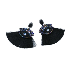 Close-up of black evil eye tassel earrings featuring colorful beads and crystal studs