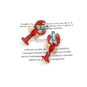 Chic lobster drop earrings with red rhinestones and blue crystals on a gold base
