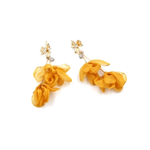 Macro detail of yellow fabric flower earrings with pearls and crystal rhinestones