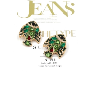Vue détaillée de boucles d'oreilles poisson tropical avec cristaux verts et perles