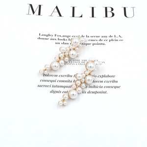 Eleganti orecchini lunghi di perle barocche con base dorata in stile minimalista
