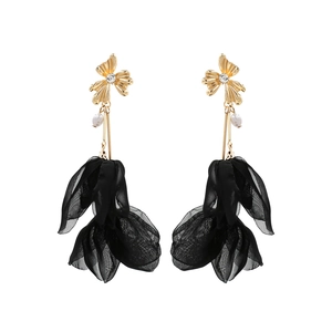 Detail of floral earrings with gold petals, white pearls and black tulle fabric layers