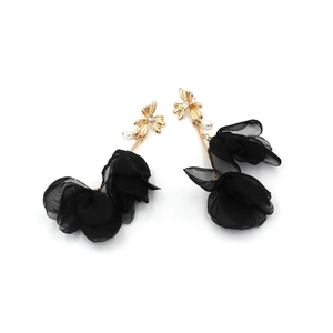 Close-up of gold flower earrings with black mesh petals, rhinestones and small pearls