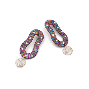 Detailed shot of handmade colorful thread wrap earrings with marble textured beads