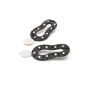 Macro view of teardrop earrings featuring black mesh weave and sparkling crystals