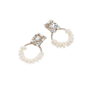 Boucles d'oreilles dorées avec diamant carré et cercle de perles sur fond blanc