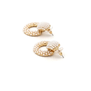 Detailed view of gold-tone hoop earrings with white faux pearl pavé on a white background