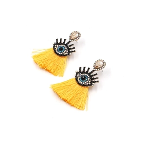 Detail of bohemian evil eye earrings with blue crystals and bright yellow silk tassels