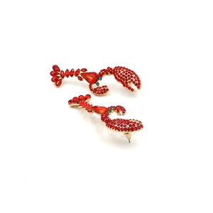Sparkling red rhinestone lobster earrings with gold metal base and green gem eyes