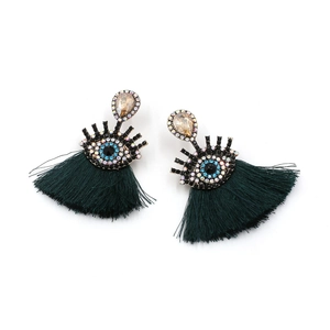 Detail of evil eye earrings with champagne drop stones and long dark green tassels