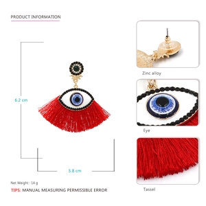 Fashionable evil eye tassel earrings with blue enamel and red fringe details