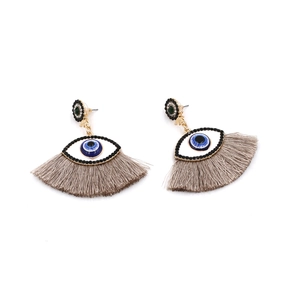 Detailed view of fashion evil eye earrings with grey silk tassels and sparkling rhinestones
