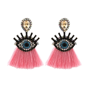 Detail view of evil eye earrings featuring blue crystal inlay and vibrant pink tassels
