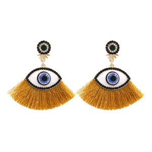 Detail of evil eye tassel earrings with blue rhinestones and yellow fringe accents
