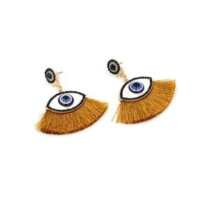 Detail view of gold tassel Evil Eye earrings with blue crystal accents and silk fringe