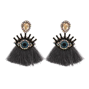 Detail view of champagne crystal drops and evil eye charms with grey silk tassels