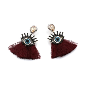Detailed view of bohemian devil eye earrings with burgundy silk fringe and rhinestones