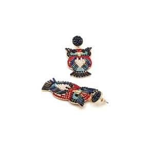 Détail de la marqueterie de strass et perles sur des boucles d'oreilles hibou