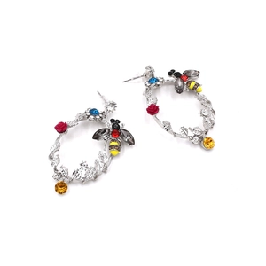 Dettagli di orecchini a cerchio vintage in argento con cristalli colorati e api decorative