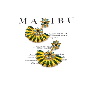 Detailed shot of bohemian fan earrings with yellow beads and green marquise rhinestones