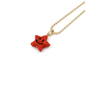 Star pendant necklace with orange crystals and smiling face on golden bead chain