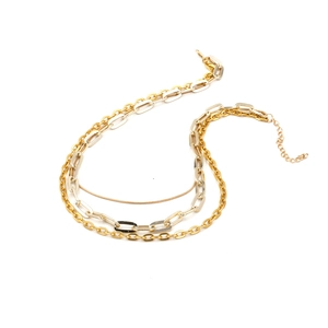 Collier multi-rangs à maillons épais or et argent sur fond blanc style minimaliste