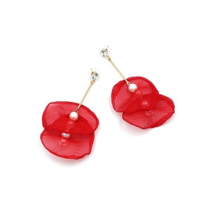 Detail of long floral drop earrings with red fabric petals, pearls, and gold finish