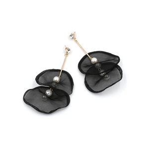 Close-up of elegant long lace flower earrings with black petals and pearls details