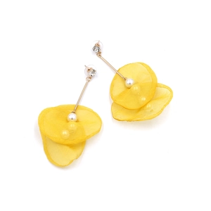 Detailed macro view of yellow lace flower petals with white faux pearl drop earrings
