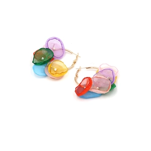 Dettaglio di orecchini a cerchio dorati bohémien con fiori colorati in organza e perle