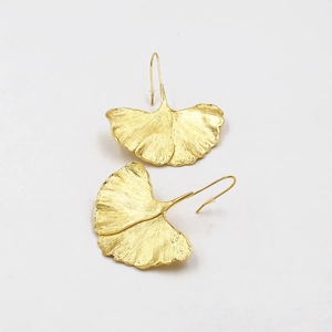 Golden alloy ginkgo leaf drop earrings with detailed vein texture on white background
